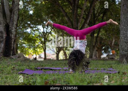 Fille latino-américaine s'amusant dans le parc faisant des exercices de gymnastique avec dextérité. Banque D'Images