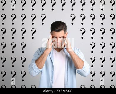 L'amnésie. Homme confus et points d'interrogation sur fond clair Banque D'Images