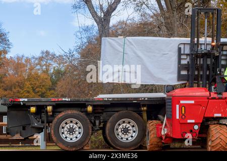 Utilisation d'un chariot élévateur sur le chantier de construction pour livrer les matériaux de construction Banque D'Images