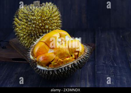 Fruit Lai ou Elai, un des fruits endémiques de Bornéo. Famille avec fruits Durian ou Durio. Photo d'ambiance sombre avec fond en bois. Banque D'Images