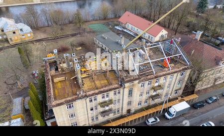 Photographie par drone de travailleurs de la construction construisant un nouveau toit sur un vieux bâtiment pendant la journée ensoleillée du printemps Banque D'Images