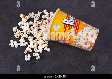 Pop-corn dispersé du seau jaune sur fond sombre Banque D'Images