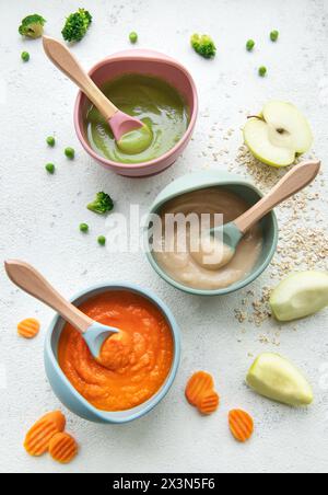 Aliments sains pour bébés dans des bols. Divers bols de purée de fruits et légumes, vue de dessus Banque D'Images