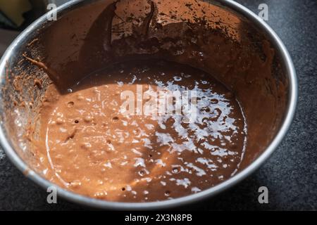 Mélange de cupcake au chocolat dans le bol à mélanger en métal gros plan. Banque D'Images