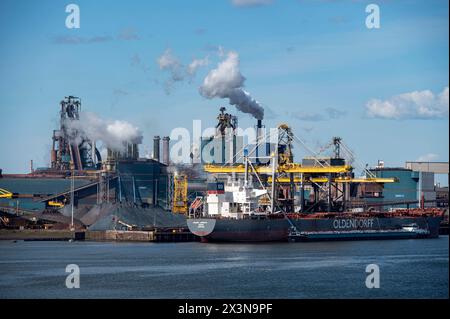 IJmuiden pays-Bas 22 avril 2024 vue à travers l'eau à l'industrie lourde de Tata Steel Mills soufflage de fumée de ses processus. Amarré sur le quai des vraquiers Christine Oldendorff avec un navire d'avitaillement à côté. staalfabriek, industrie, expédition Banque D'Images