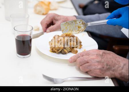 Gros plan d'une infirmière qui sert de la nourriture à des personnes âgées dans une maison de retraite. Photographie de haute qualité Banque D'Images