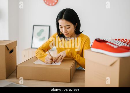 Femme freelance de petite entreprise préparant des paquets pour la livraison au client Banque D'Images