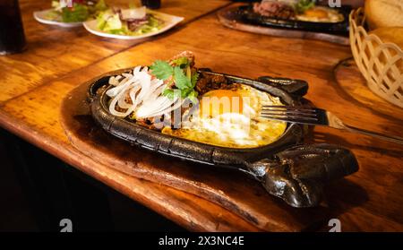 Bo ne trung, bœuf cuit dans une plaque chauffante avec sauce et œufs petit déjeuner vietnamien. Bo ne, un petit-déjeuner vietnamien traditionnel avec steak, œufs et bague Banque D'Images