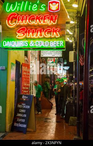 Quartier français, la Nouvelle Orléans, Louisiane. Trottoir de la rue Bourbon la nuit. Les hommes habillés en vert pour célébrer la Saint-Patrick. Banque D'Images