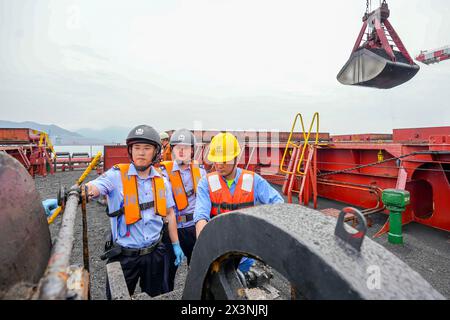 FUZHOU, CHINE - 28 AVRIL 2024 - la police au poste de contrôle frontalier entrée-sortie de Fuzhou au port de Huaneng (Fujian) dans la baie de Luoyuan, Chine, guide la personne i. Banque D'Images