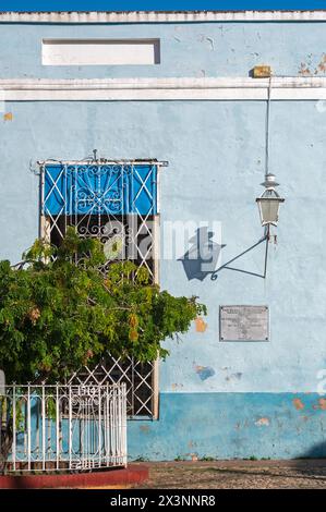 Une vieille lampe en métal projetant une ombre sur un mur peint en bleu dans les ruelles de la vieille ville, Trinidad, Cuba. Banque D'Images