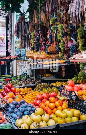 Stalle de marchand de fruits dans les rues de Tbilissi, avec des pommes, des grenades, des prunes, des raisins, et Churchkhela géorgienne Banque D'Images