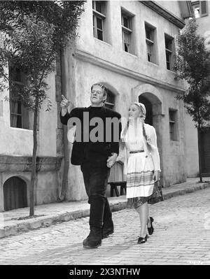 LON CHANEY Jr. dans son Frankenstein Monster Make-up Strolls on the European Village se déroulant aux studios Universal avec ELAINE MOREY lors d'une pause dans le tournage DU FANTÔME DE FRANKENSTEIN 1942 le réalisateur ERIC C. KENTON Make-up JACK PIERCE Music HANS J. SALTER Universal Studios Banque D'Images