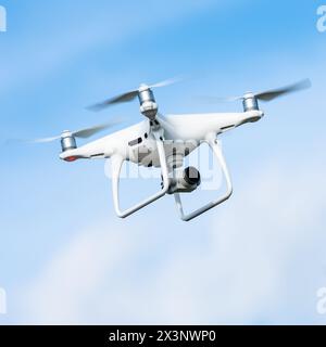Véhicule aérien sans pilote drone drone quadrocopter ou quadrorotor DJI avec caméra en action dans le ciel et tourne la vidéo autour de lui de la vue d'oiseau dans le soleil Banque D'Images