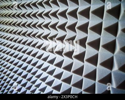 Panneaux acoustiques en mousse. Panneaux gris à motif pyramidal pour l'insonorisation et la réduction du bruit. Banque D'Images