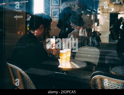 Paris, 02.04 2024 : TravelPictures, Un homme boit de la bière dans un restaurant. Banque D'Images