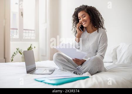 Jeune femme travaillant à domicile sur un jour lumineux Banque D'Images
