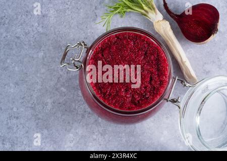 Sauce crémeuse au raifort de betterave en pot sur fond gris. Apéritif ou condiment pour viande et poisson. Nourriture végétalienne saine. vue de dessus. Banque D'Images