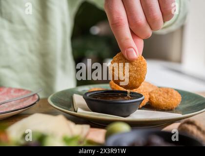 Gros plan sur des en-cas au fromage frits trempés dans une sauce Chili sucrée dans un café-restaurant Banque D'Images