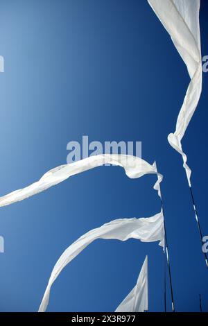 Draps blancs soufflant dans le vent contre un ciel bleu d'été Banque D'Images