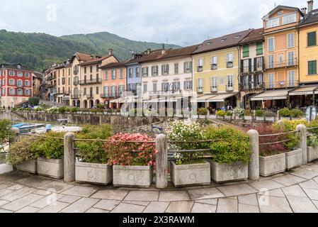 Cannobio, Piémont, Italie - 26 avril 2024 : au bord du lac de Cannobio avec bars et restaurants en plein air, la station balnéaire populaire sur la rive du lac M. Banque D'Images