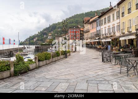 Cannobio, Piémont, Italie - 26 avril 2024 : au bord du lac de Cannobio avec bars et restaurants en plein air, la station balnéaire populaire sur la rive du lac M. Banque D'Images