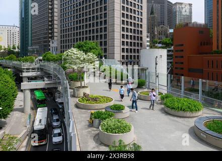 Les gens marchent sur Seoullo 7017, un parc linéaire à Séoul. Seoullo 7017, également connu sous le nom de Seoul Skygarden ou Skypark, est un parc linéaire surélevé à Séoul, construit au sommet d'un ancien pont autoroutier. Le sentier, d'environ un kilomètre de long, bordé de 24 000 plantes, a été ouvert en mai 2017. Le chemin améliore également les temps de marche pour les gens autour de la gare centrale de la ville. Le passage supérieur désaffecté a fermé en 2015 et coupe en diagonale la gare de Séoul à 17m au-dessus du niveau de la rue. Le '70' dans le nom vient de l'année 1970 où le flyover a été dédié, tandis que le '17' est à la fois le nombre de w Banque D'Images