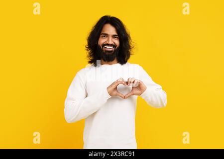 Homme indien créant une forme de coeur avec les mains Banque D'Images