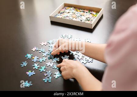 Femme assemblant un puzzle bleu et blanc Banque D'Images