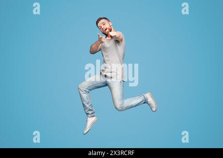 Cheerful man en sautant indiquant joyeusement à vous Banque D'Images