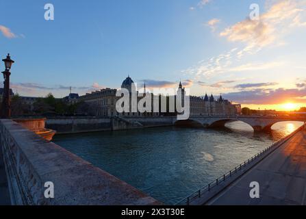 Coucher de soleil spectaculaire sur la Seine et Conciergerie à Paris, France, avec pont Pont neuf. Fond de voyage coloré. Banque D'Images