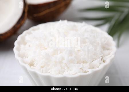 Flocons de noix de coco dans un bol sur la table, gros plan Banque D'Images