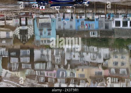 Les maisons peintes au pastel caractéristiques se reflètent dans le port à marée basse. Port de Brixham, Devon, Royaume-Uni Banque D'Images