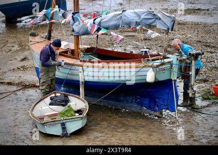 Les propriétaires de bateaux profitent de la marée basse pour effectuer l’entretien de leurs bateaux. Port de Brixham, Devon, Royaume-Uni Banque D'Images