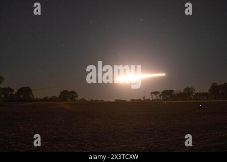 Un High Mobility Artillery Rocket Systems (HIMARS) de la batterie Alpha « Able », 3-321st Field Artillery Regiment (FAR) de la 18th Field Artillery Brigade (FAB) illumine le ciel nocturne de Fort Campbell, Kentucky, lors d’un assaut aérien à grande échelle à longue portée dans le cadre de l’opération Lethal Eagle 24.1, 24 avril 2024. La batterie « Able » a soutenu la 101e division aéroportée (assaut aérien) en fournissant deux HIMARS M142 pour tirer six fusées d’entraînement à portée réduite M28 (LCRRPR) à l’appui d’un exercice de tir de masse multidomaine de la division. Des soldats de la batterie Able se sont rendus à Fort Campbell, Kentucky, depuis Fort Banque D'Images