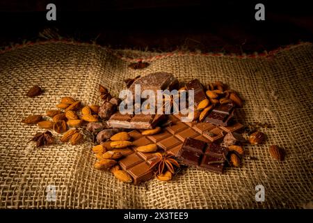 Photographie de morceaux de chocolat avec des amandes sur un fond rustique sur un sac Banque D'Images