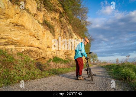 Cycliste masculin senior chevauchant un vélo pliant sur Steamboat trace, piste cyclable convertie à partir d'un chemin de fer abandonné, près du Pérou, Nebraska, matin de printemps Banque D'Images