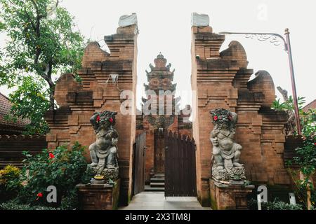 Temple balinais connu sous le nom de « Pura » porte d'entrée généralement connu sous le nom de « Candi Bentar » avec deux statues gardiennes flanquant les côtés appelés Dwarapala Banque D'Images