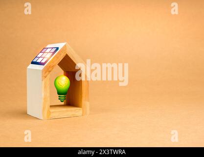 Concept de durabilité à la maison. Ampoule électrique verte dans le modèle de maison blanche avec des panneaux solaires sur le toit d'isolé sur fond de papier recyclé avec Banque D'Images