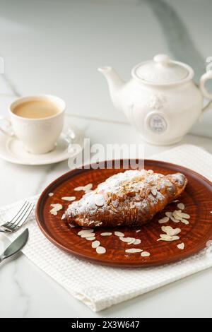 Croissant d'amandes sur plaque d'argile de près Banque D'Images