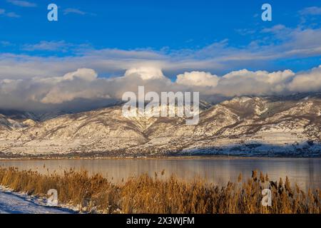 Les nuages pendent bas sur les montagnes Wasatch par un jour ensoleillé de janvier à l'unité 1 de la zone de gestion de la sauvagine de la baie de Farmington, Farmington, Utah, États-Unis. Banque D'Images