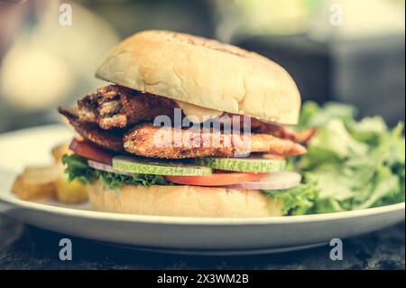 street food fishburger avec côtelette de poisson et légumes sur plaque blanche. Banque D'Images