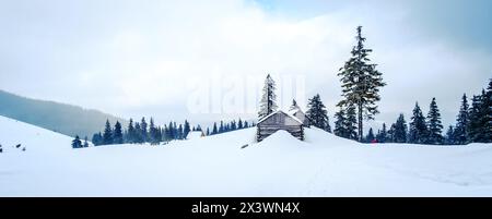 Petites maisons en bois sur la colline des montagnes en hiver. Paysage hivernal pittoresque de montagnes Banque D'Images