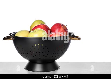 Pommes fraîches en passoire sur table sur fond blanc. Espace pour le texte Banque D'Images