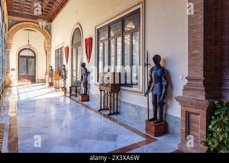 Séville, Espagne - 26 avril 2024 : couloir décoré d'armures à l'intérieur du bâtiment de la Plaza de España à Séville, Andalousie, Espagne. Siège social de t Banque D'Images