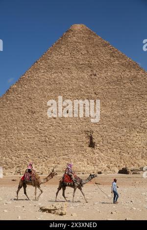 Touristes à dos de chameaux, complexe pyramidal de Gizeh, site du patrimoine mondial de l'UNESCO, Gizeh, Egypte Banque D'Images