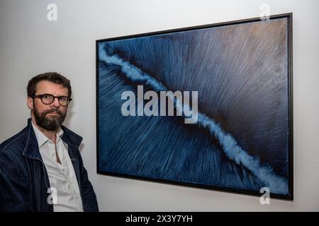 Londres, Royaume-Uni. 29 avril 2024. L’artiste Tobias Munthe avec son œuvre « Edge », 2019, en avant-première des œuvres d’art pour « AT the bus », une exposition d’œuvres offertes par des artistes de premier plan pour soutenir la charité, offrant l’art comme thérapie pour les jeunes. L’exposition est ouverte au public du 29 avril au 7 mai dans les galeries Sotheby’s New Bond Street, après quoi les œuvres seront mises en vente dans une vente aux enchères en ligne propulsée par Artsy. Credit : Stephen Chung / Alamy Live News Banque D'Images