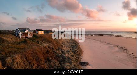 Vue aérienne des cabanes de plage éloignées avec une vue sur la mer sur les dunes de sable Northumbrian surplombant la plage d'Embleton Bay au coucher du soleil Banque D'Images