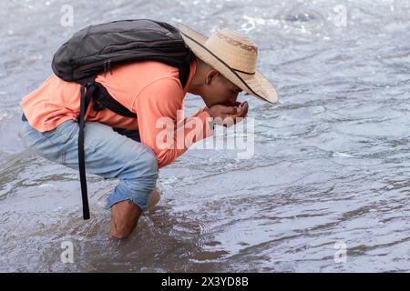 style de vie. jeune homme latin buvant de l'eau des fontaines d'eau Banque D'Images