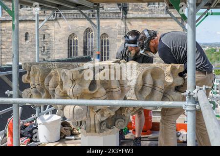 Die Steinmetzmeister Norman Hein und Markus Funke von der Firma Nuethen Nüthen Restaurierungen aus Erfurt arbeiten am 29.04.2024 am unteren Teil einer Kreuzblume am Magdeburger Dom. Teil der Sanierungsarbeiten ist die Sanierung der doppelten Kreuzblume als oberer Abschluss, die fuer entsprechende Restaurierungsarbeiten vor CA. Einem Jahr abgenommen wurde. Der obere Teil und der Fuss der Kreuzblume wurden im Zuge der Arbeiten erneuert, da sie zu stark geschaedigt waren. Der grosse, mittlere Teil konnte erhalten werden. Insgesamt erfolgt eine statische Stabilisierung der Bekroenung. Par Kran wur Banque D'Images